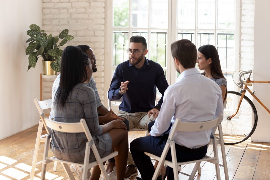 Male psychologist therapist speak at group therapy session helping those addicted to prescription drugs