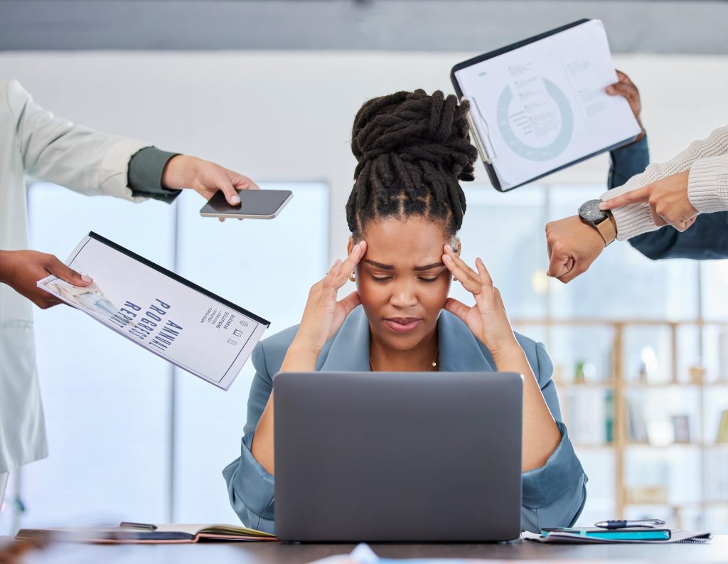 woman with headache being handed work