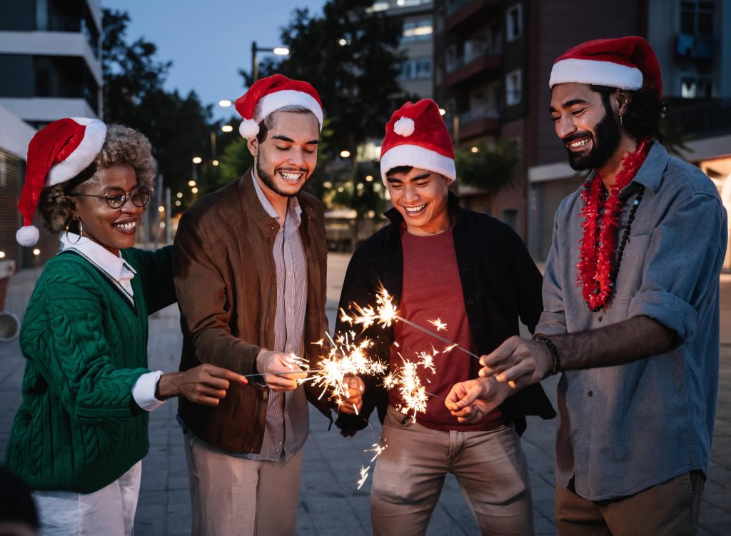 Group of happy friends celebrating Christmas together with Christmas hats on